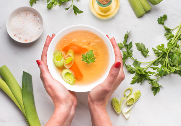 Warm bone broth with carrots and leeks, a collagen-rich soup supporting gut and joint health.
